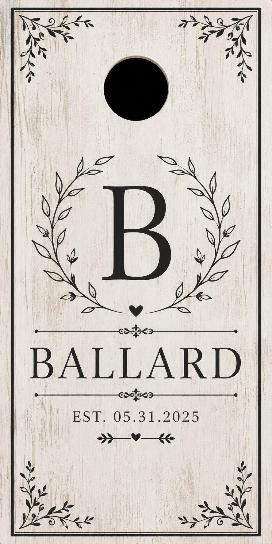Personalized cornhole board with a distressed white wood background, featuring a black circular hole near the top, a large letter B enclosed in a leaf wreath, the name BALLARD, and the date EST. 05.