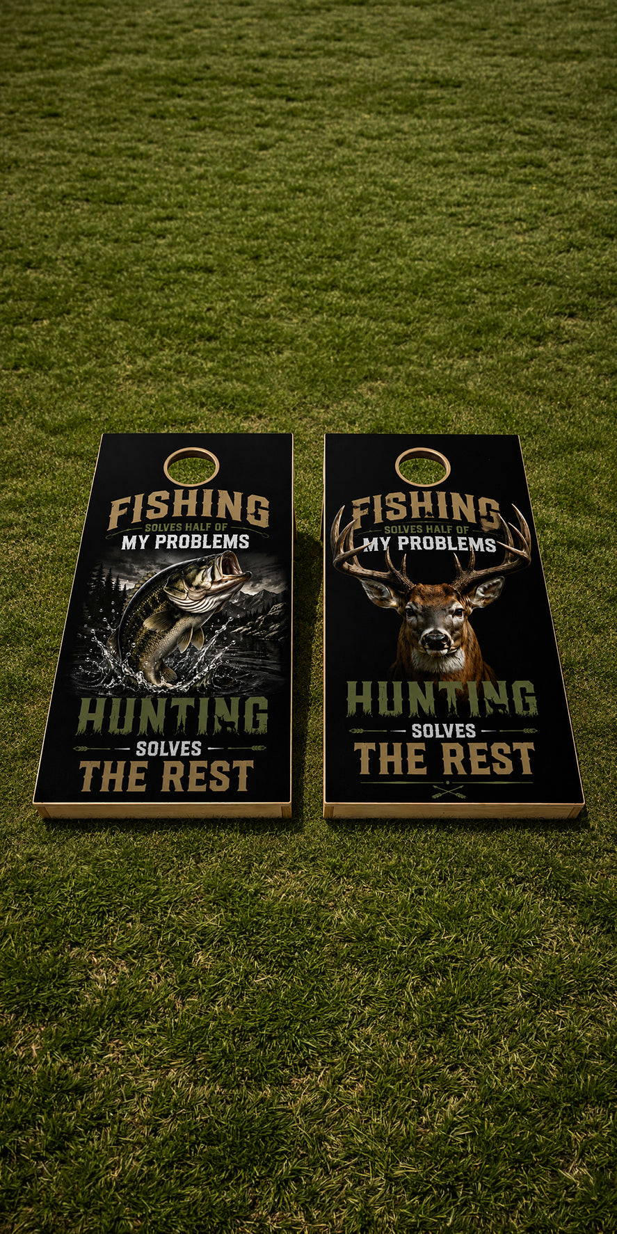 Two cornhole boards with hunting and fishing-themed graphics placed on a green grass lawn. The boards feature black backgrounds with fish and deer illustrations, gold text reading 'FISHING MY PROBLEMS' and 'HUNTING SOLVES THE REST,' plus a circular gold emblem near the top of each board.
